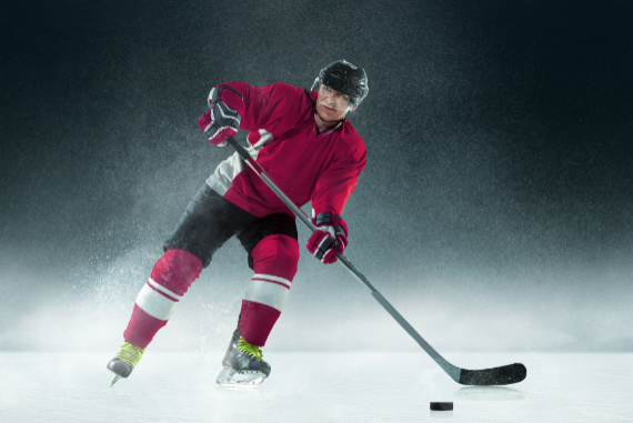 Ice Hockey World Championship 2025 - Male ice hockey player with stick on the ice rink and dark background