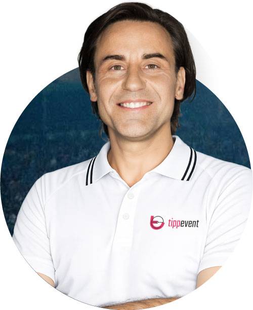 Robert, Ansprechpartner von tippevent, im Poloshirt mit tippevent-Logo vor Stadion-Hintergrund – Kontakt für individuelles Tippspiel